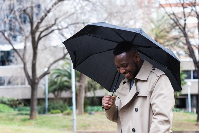 Happy stylish Black man with umbrella