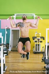 Front of man working out shoulders in a fitness club on pull up bar 5wQEmb