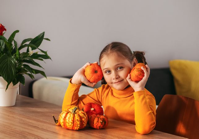 Little Girl Playing With a Pumpkin.