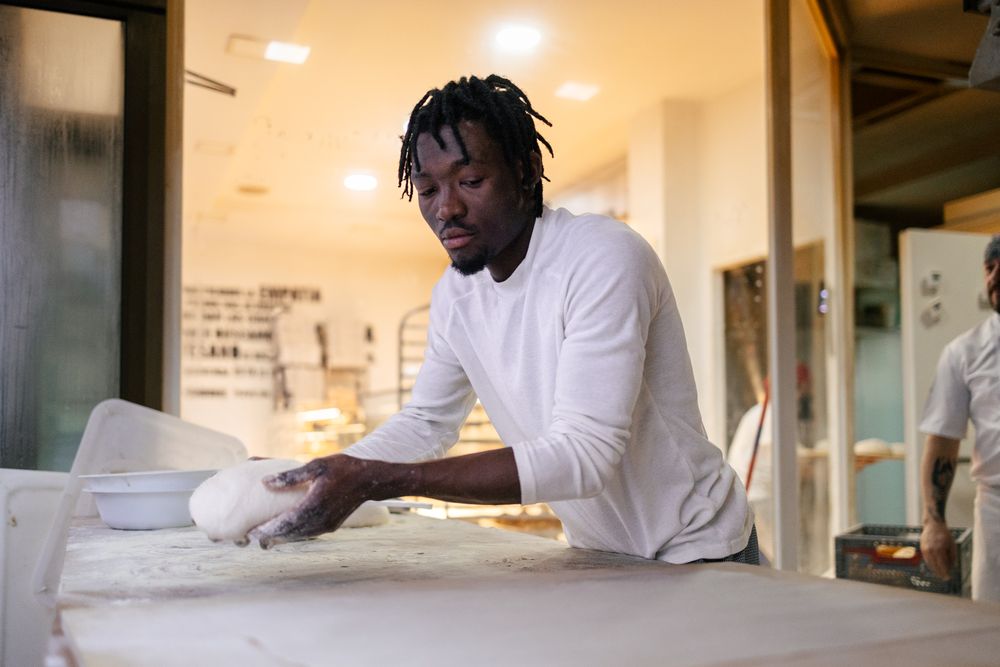 Black baker with a dough in his hands