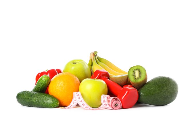 Dumbbells, measuring tape and fruits isolated on plain background