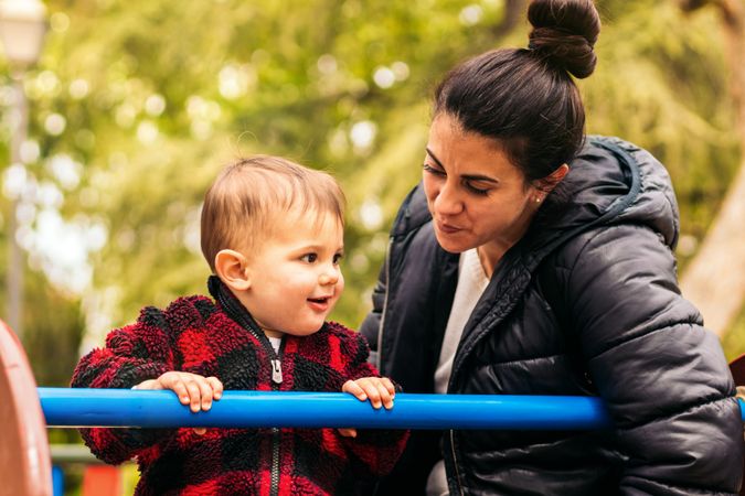 smiling mother and baby playing in a playground