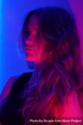 Portrait of teenage girl looking away in purple lit studio 4M7Xy0