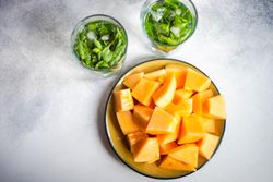 Bowl of melon served with minty drink