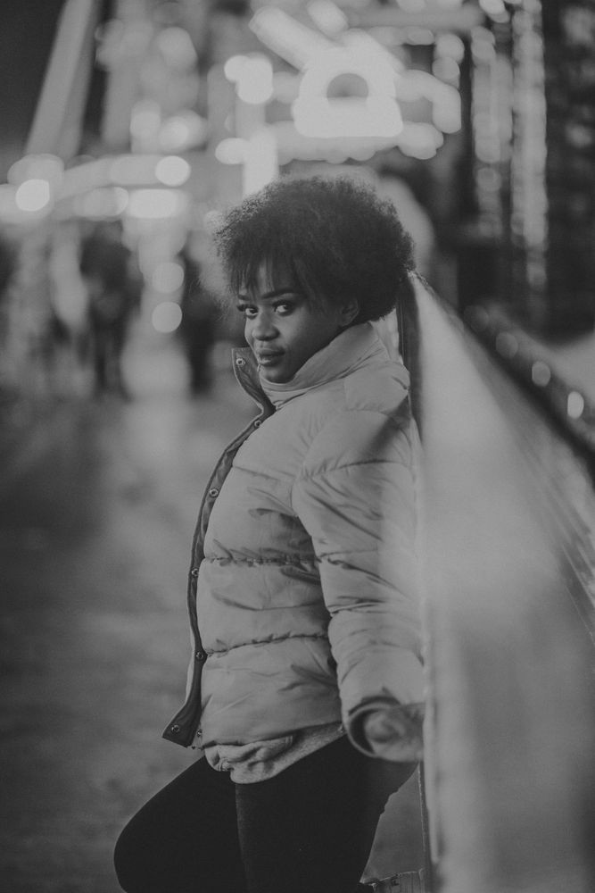 Black female standing near attraction in amusement park