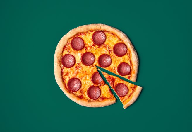 Pizza salami top view minimalist on a green background