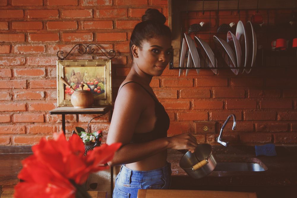 Woman holding stainless steel kettle standing in kitchen