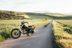 Motorcycle on countryside road near grass