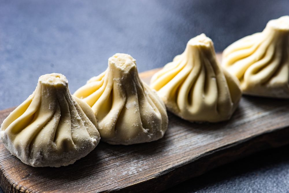Traditional Georgian khinkali dumplings served on wooden board with copy space