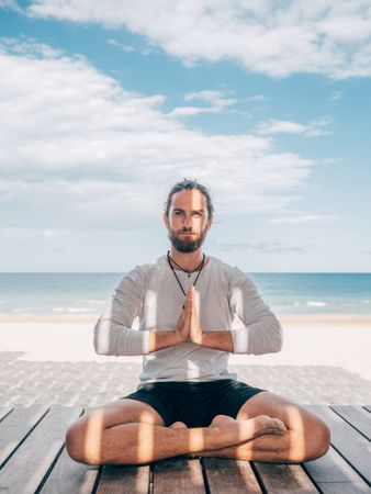 Man meditating on beach