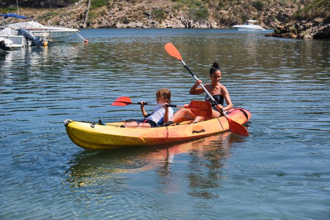 Mother with son rowing kayak on sea