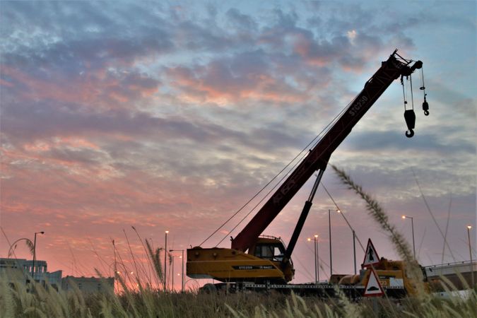 Large crawler crane on land at sunset in Doha, Qatar