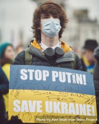 London, England, United Kingdom - March 5 2022: Young man in facemask with Ukrainian flag sign 5wn3L0