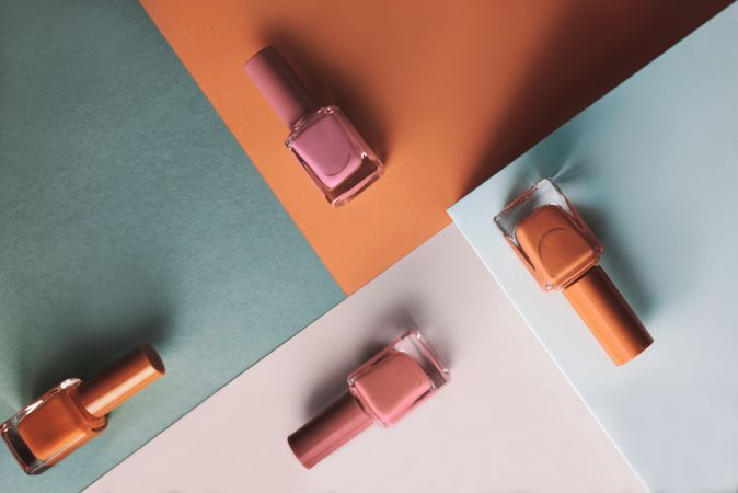 Multi-colored nail polish on pastel colors geometric pattern background