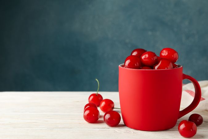 Towel and cup with cherry on wooden background