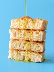 Pouring olive oil over focaccia bread
