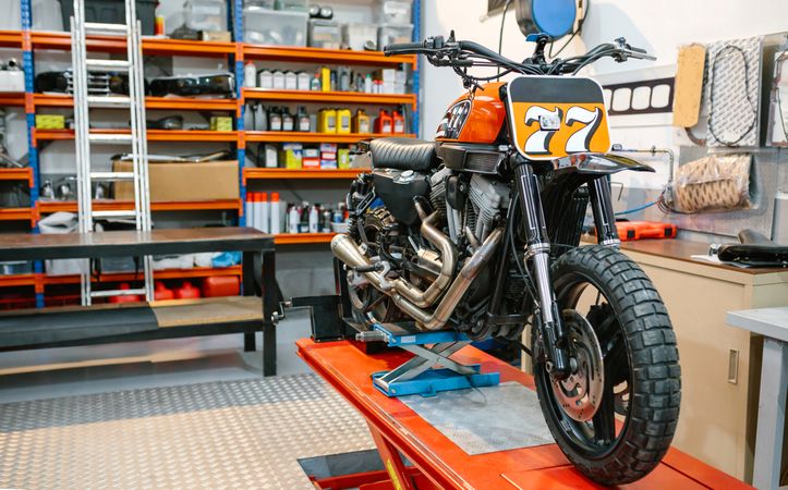 custom motorcycle over platform ready to check on empty workshop