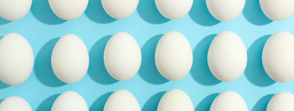 Flat lay composition with chicken eggs on color background, space for text