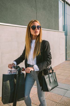 Woman with shopping bags on electric scooter