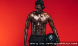 Fit young man with medicine ball standing against red background 4mP2o5