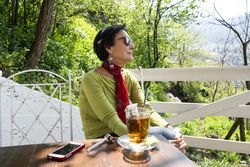 Elegant older woman relaxing with a cup of tea and pipe