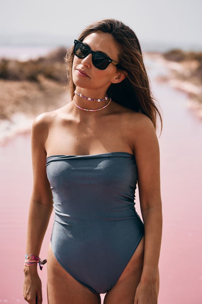 Appealing female in swimsuit posturing on beach