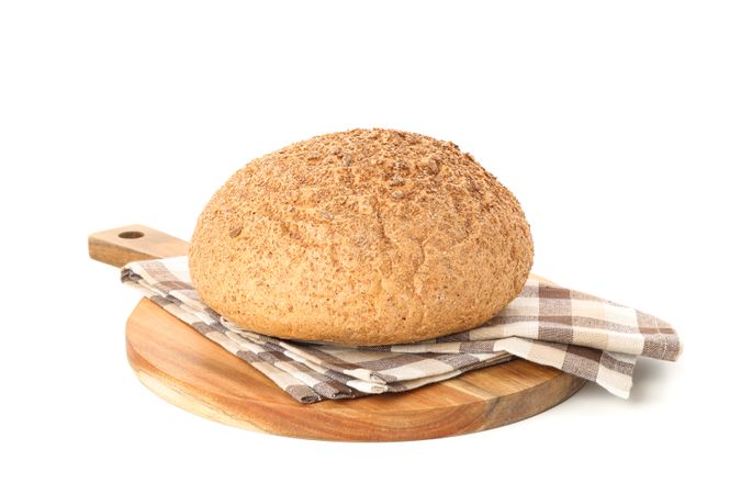 Wheat bread and kitchen towel on cutting board isolated on blank background