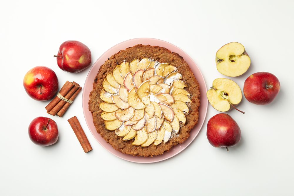 Composition with tasty apple pie on neutral background, top view