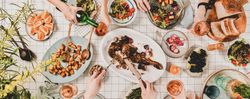 Flat-lay of hands of people eating and wine being poured