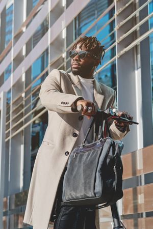 Stylish Black man in sunglasses with hand bag