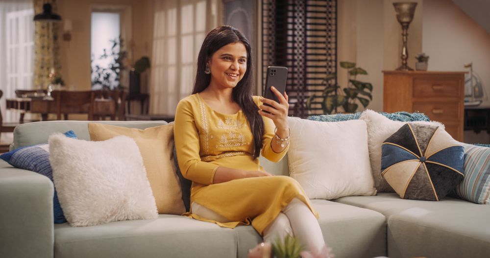 Young Indian Woman Making a Video Call on Her Smartphone at Home, Sharing Laughs and Gossip with Girlfriends