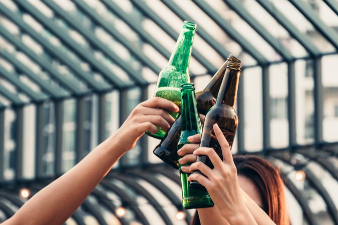 Group of people celebrating party by toasting drinks on rooftop