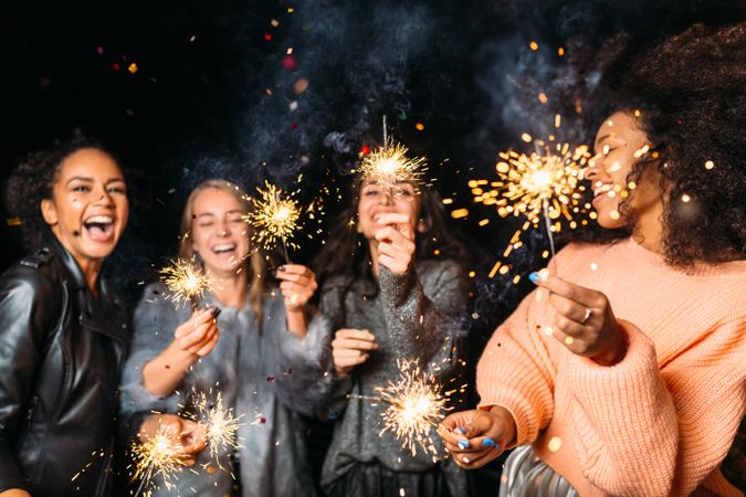 Multi-ethnic group of happy women at fun party with sparklers