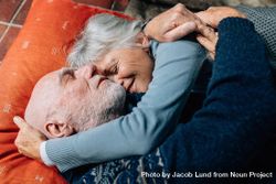 Smiling woman sleeping in the arms of her husband holding his head 0yzYj5