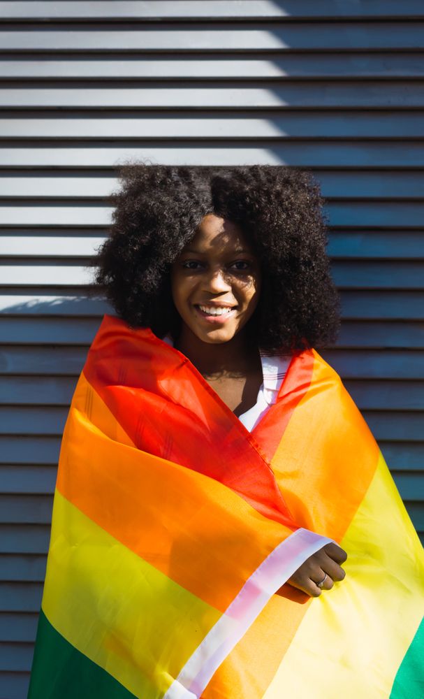 Woman posing happily with the LGBT flag