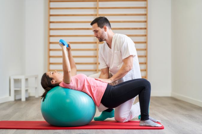The physiotherapist performing rehabilitation exercises with the