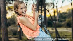 Happy girl swinging on a tire swing in a park 5p1mg4