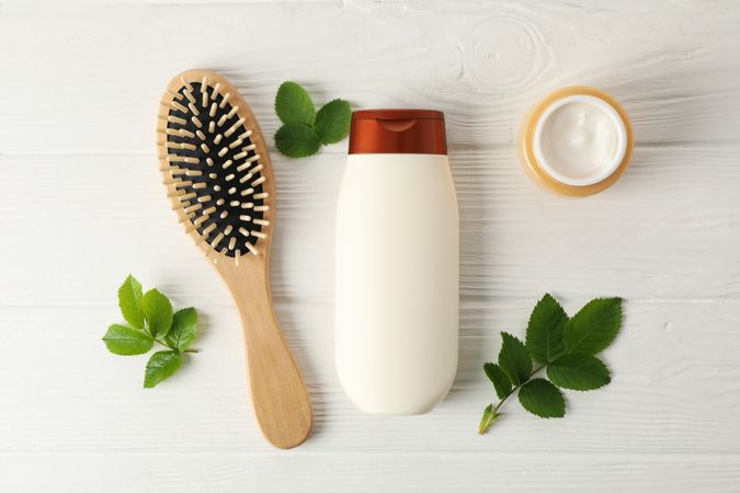 Composition with hair care products on wooden background, top view