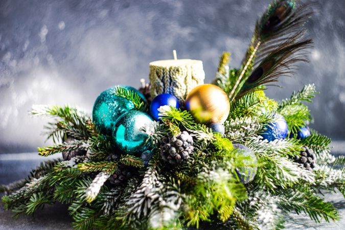 Side view of blue and gold Christmas baubles in pine centerpiece