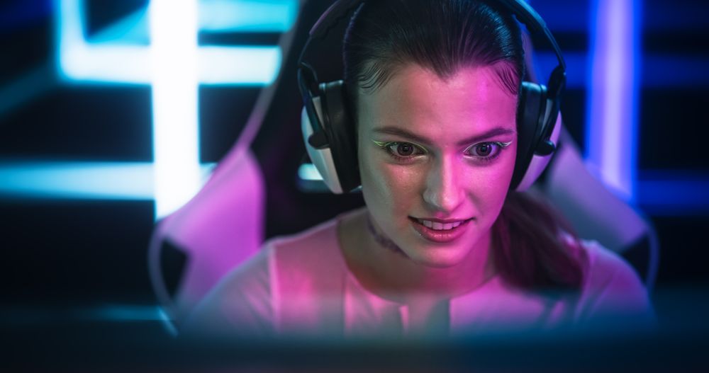 Stylish Young Female with Striking Make Up Playing and Streaming Online Video Games From a Bright Neon Room