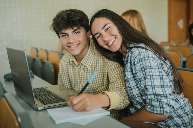 Happy teen couple during lecture in university