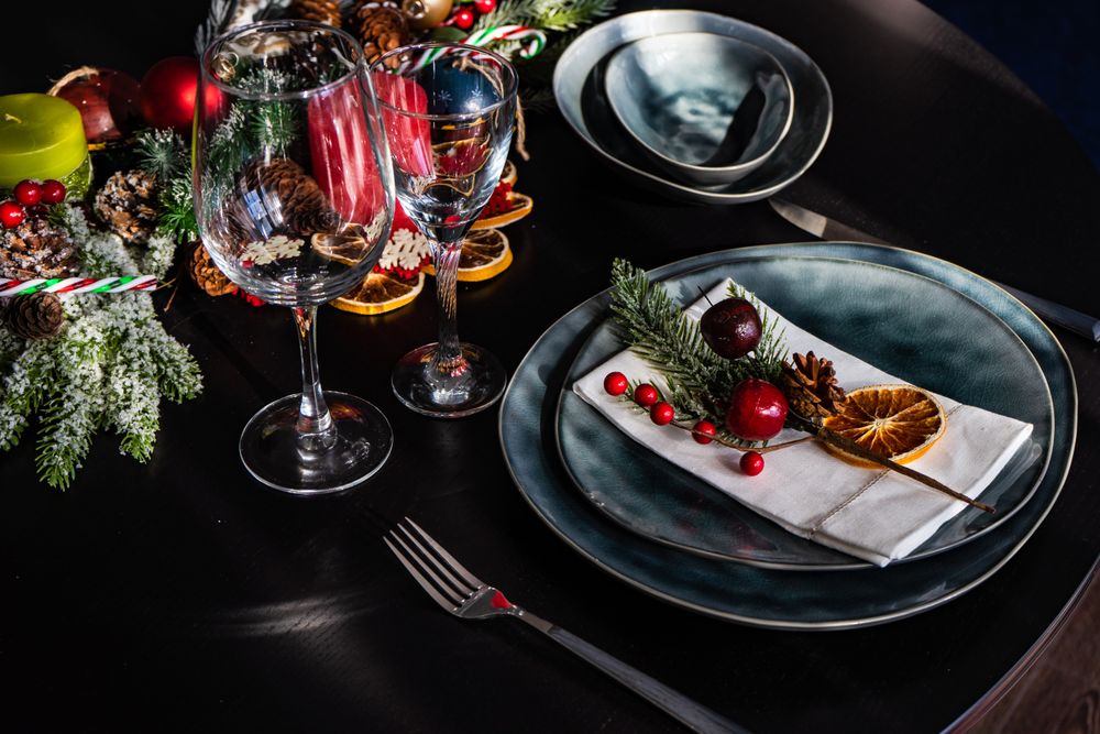 Navy holiday table setting with decorative berries and dried orange slice