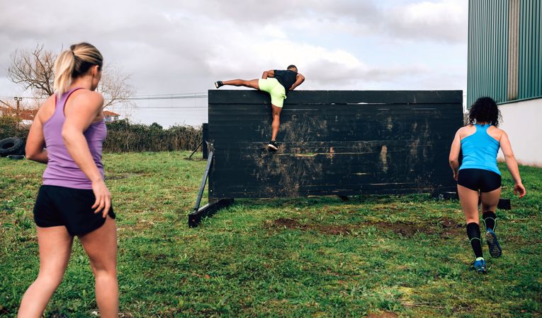 Participants in obstacle course climbing wall