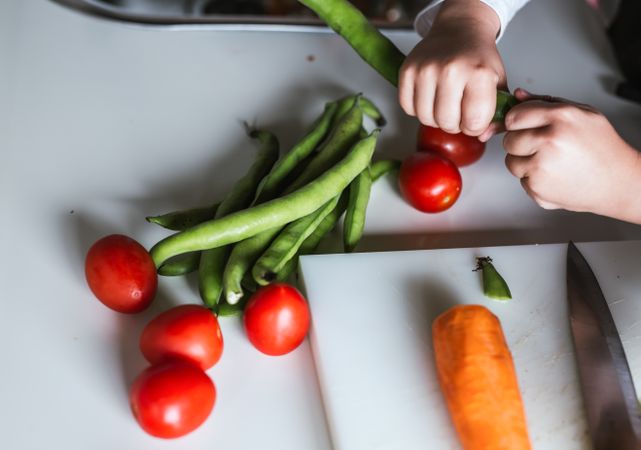 Anonymous boy preparing vegetables for salad