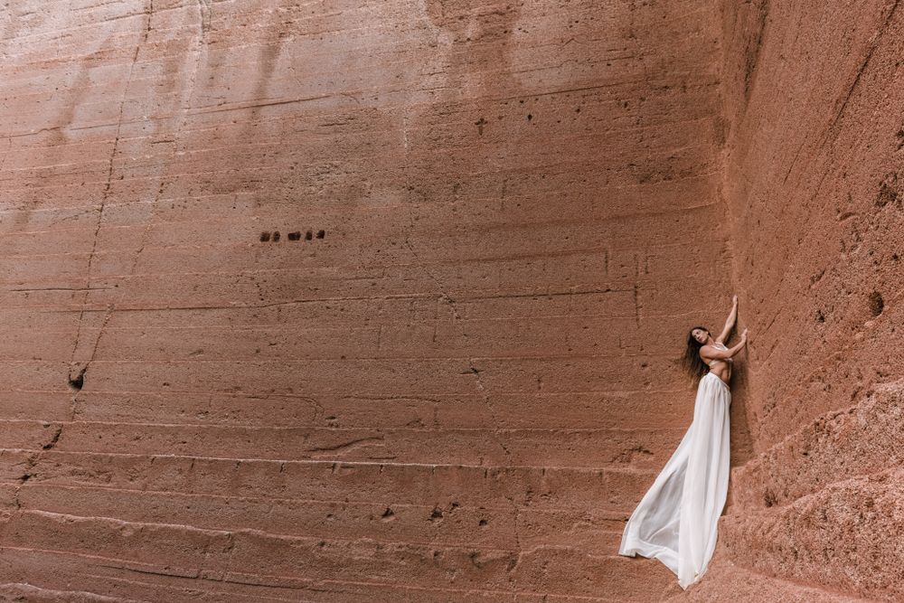 Elegant female posing on rocky cliff