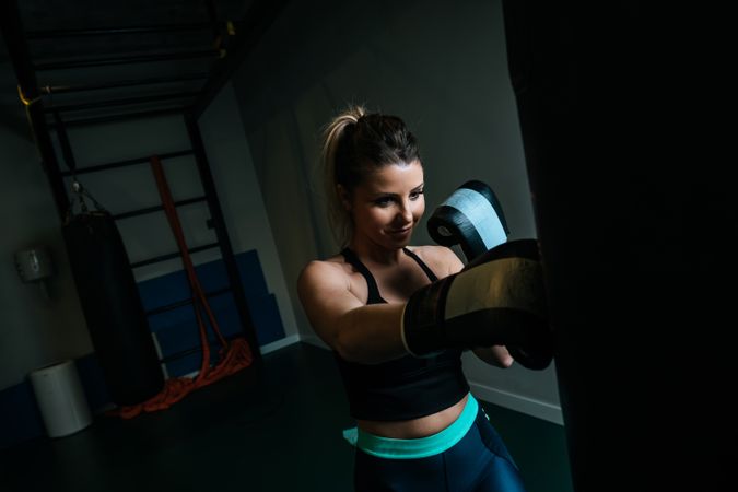 Woman training in gym with punching bag