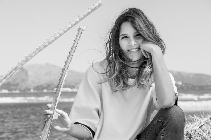 Young woman sitting near dried plants