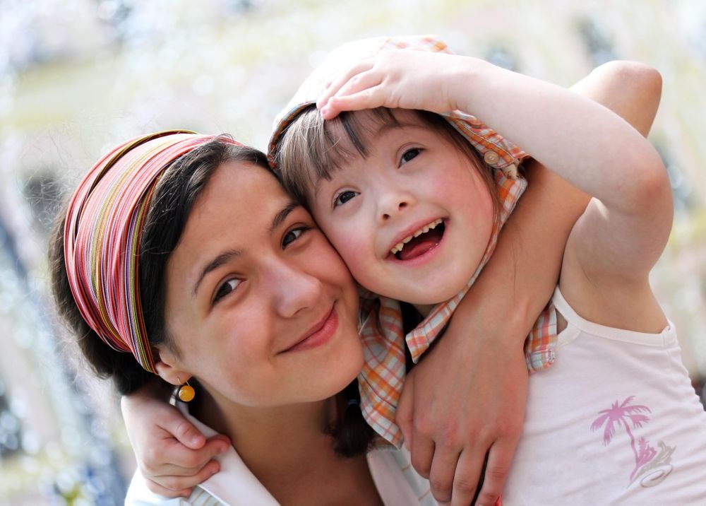 Two sisters embracing outside