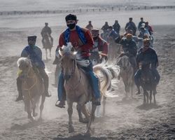 Group of men from The Tengger tribe riding horses in Bromo National Park in East Java, Indonesia 4BErE5