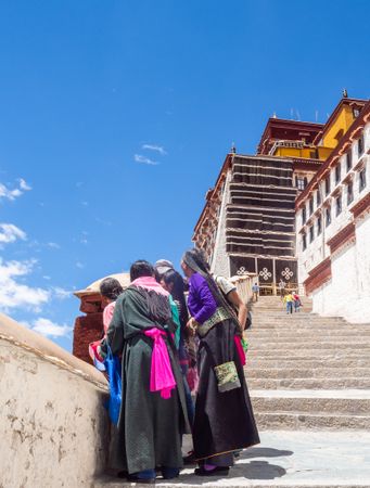 Tibet - August, 15 2015: Tourists near old temple on cloudy day